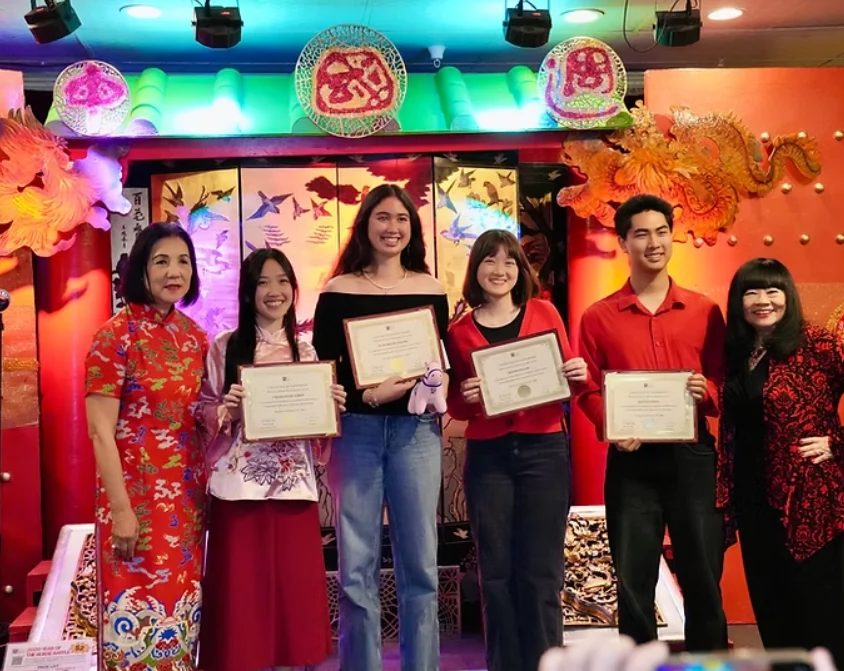 Scholarship recipients holding certificates on stage