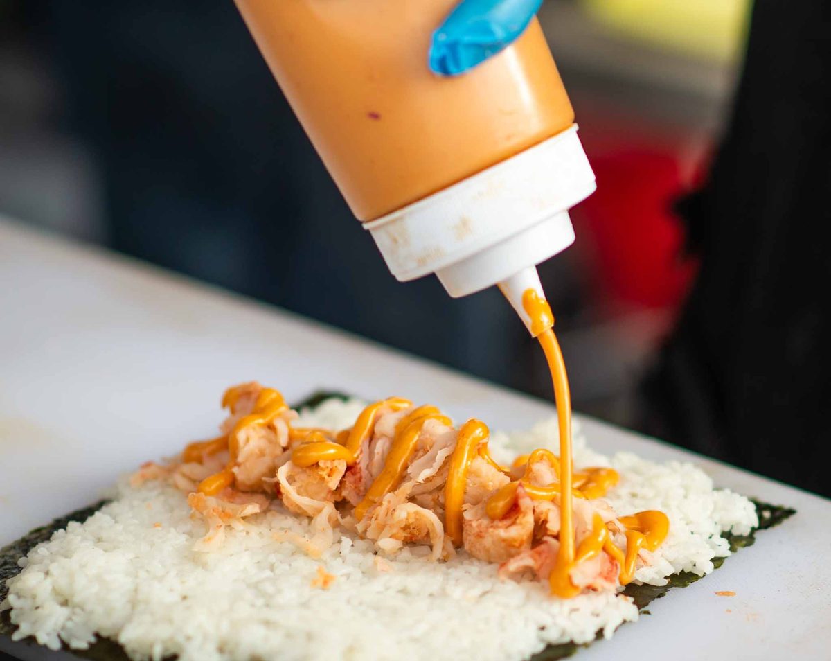 Sauce drizzled over sushi at a festival food stall